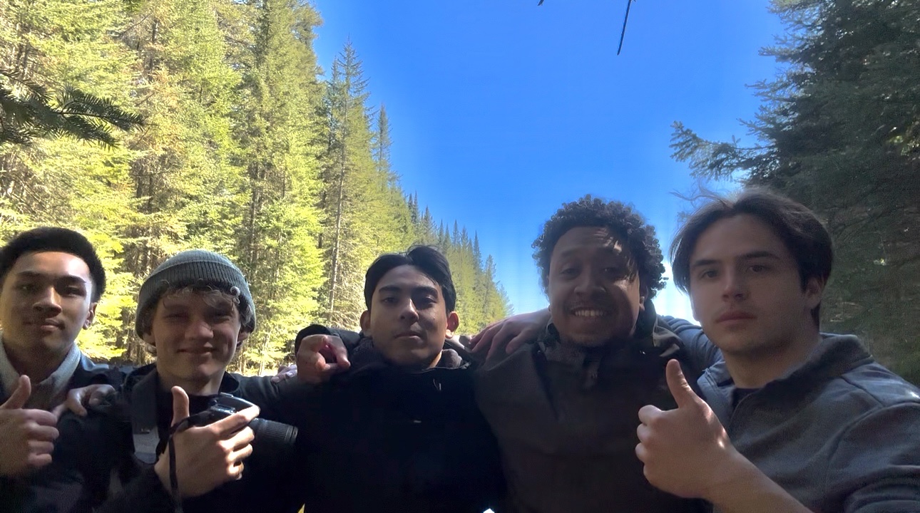 Daniel with friends in the forest during a portage trip.